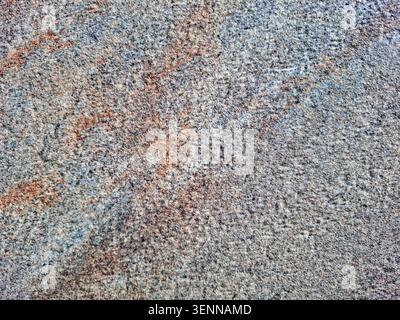 Close-up view of a ceramic tile or stone slab that showcases a textured surface with mottled patterns. The colors include shades of grey, brown, and r Stock Photo