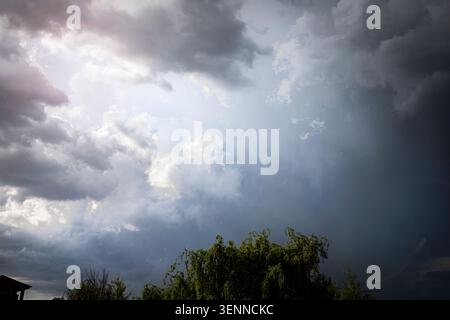 Dramatic Storm Clouds With Sun Rays Breaking Through Before Heavy Rainfall Stock Photo