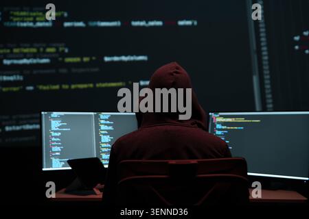 Programmer Hacker Working at Multiple Monitors Stock Photo