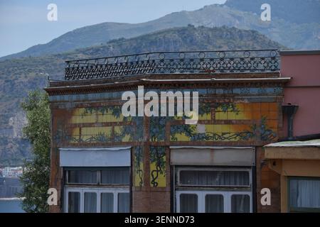 Decorative ceramic-tiled façade of a historic building in Sorrento, Campania, Italy, with the mountains of the Sorrentine Peninsula in the background. Stock Photo