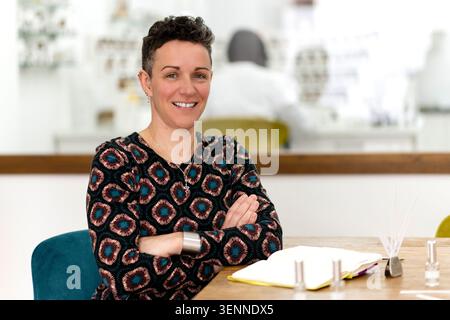 Confident female perfumer smiling in her workshop Stock Photo