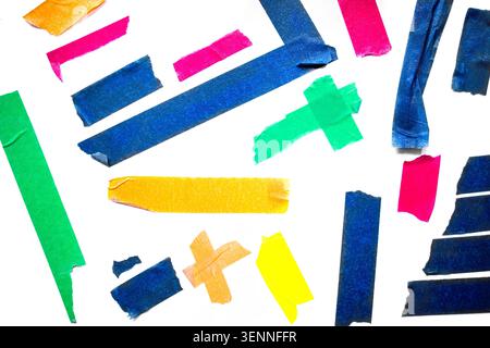 Assorted colorful adhesive tape strips in different shapes and sizes placed on a white surface, featuring bright colors like blue, green, yellow, pink Stock Photo