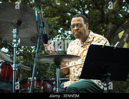 Focused musician plays drums at an outdoor concert Stock Photo