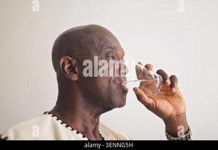 Senior man in profile drinking a glass of water Stock Photo