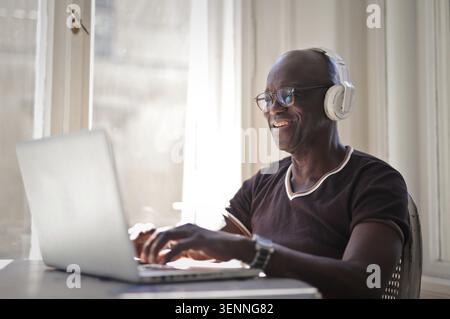 Smiling mature black man using a laptop computer at home Stock Photo