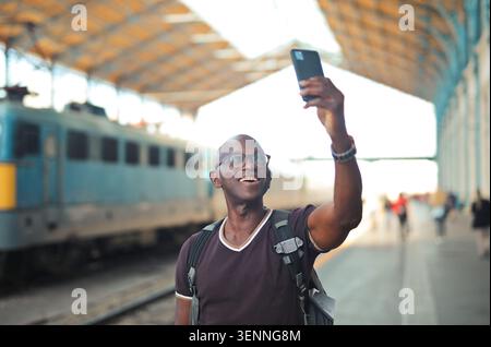 Happy mature man taking a selfie at train station Stock Photo
