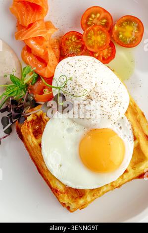 Savory waffle with eggs smoked salmon and tomato Stock Photo