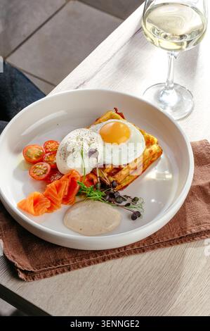 Gourmet savory waffle with eggs salmon and tomatoes Stock Photo