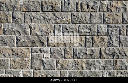 Stone wall made of square and rectangle rough granite blocks. Background and texture. Stock Photo