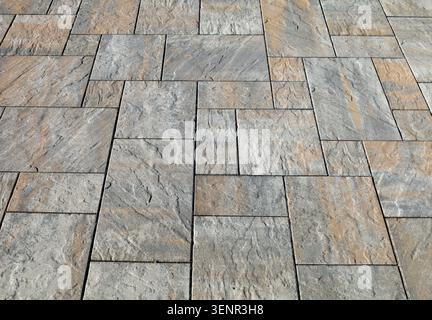Gray and brown stone paver tiles of different shapes for outdoor pavement. Background and texture. Stock Photo