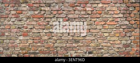 Very old brick wall made of weathered bricks in various colors with holey mortar Stock Photo