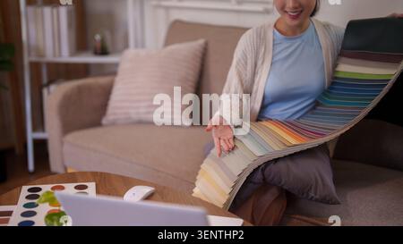 Adult woman examining color samples and material swatches for interior decoration project in modern living room Stock Photo
