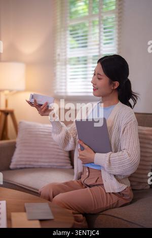 Young Asian woman reviewing material swatches and color samples for furniture design renovation at cozy living room Stock Photo