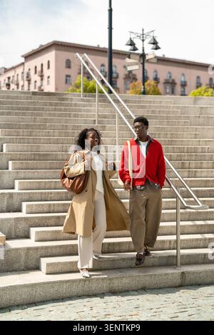 Cheerful relaxed african american man and woman strolling together in city on weekend date. Stock Photo