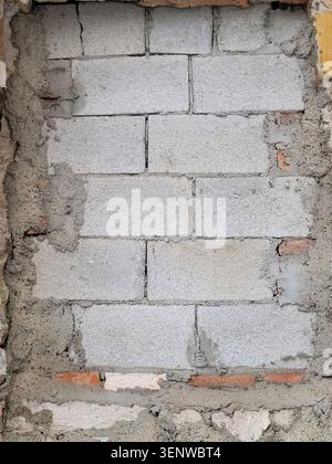 A hole in the wall filled with concrete blocks. Copy space. Texture background. Repair, construction of buildings Stock Photo