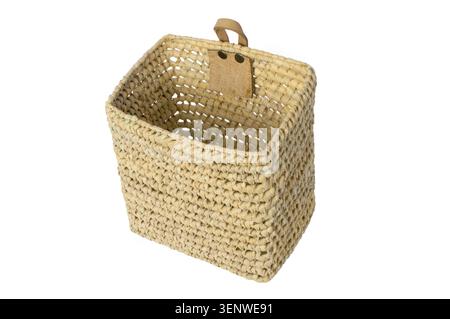 Deep rectangular wicker basket with a leather loop for hanging on the wall. Isolated on a white background. Stock Photo