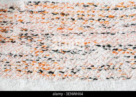 Abstract woven textile texture with white, orange and dark yarn details, close up fabric pattern for interior design and craft background Stock Photo