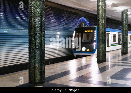 Kosmonavtlar metro station in Tashkent featuring green columns and ornate ceiling sculpture. Symmetrical underground hall with marble floors and commu Stock Photo