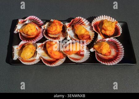 Deep-fried battered scallops in its shell on a table Stock Photo