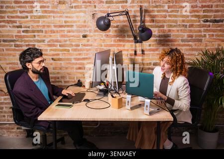 Designers working together on computers in modern office Stock Photo