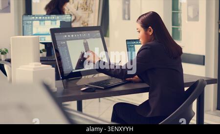 Architect working on building design with graphic software to create layout sketch for architecture project, drawing lines in small business office, designer manufacturing scale, handheld shot. Stock Photo