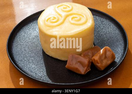 Creamy golden French handmade on farm butter from Brittany and caramel candies with sea salt flavor. Premium artisanal dairy product of Brittany. Stock Photo