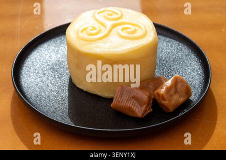 Creamy golden French handmade on farm butter from Brittany and caramel candies with sea salt flavor. Premium artisanal dairy product of Brittany. Stock Photo