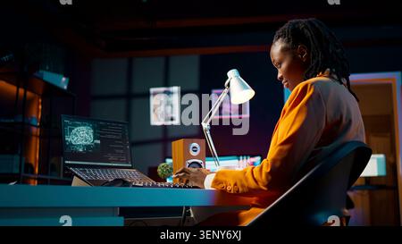 African American system engineer using AI system to write computer program code, HTML terminal window, woman works with deep learning algorithms, artificial intelligence neural networks. Stock Photo
