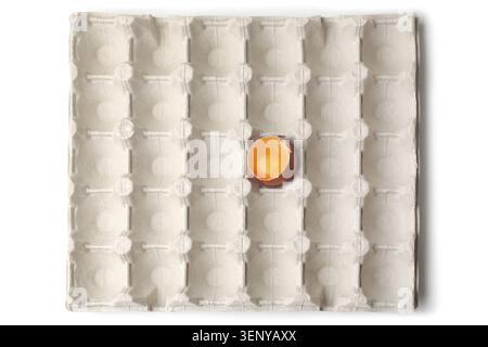 Chicken egg is half broken in egg tray on white background Stock Photo