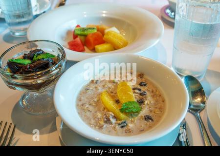 Pacific Ocean,Norwegian Cruise Line NCL Joy ship,oatmeal breakfast,cereal porridge,dried prunes,fresh fruit,fruit salad,orange slices,kiwi,pineapple,w Stock Photo