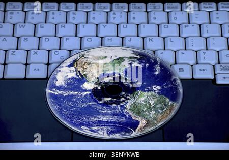 Earth are reflected in the CD on the notebook keyboard Stock Photo