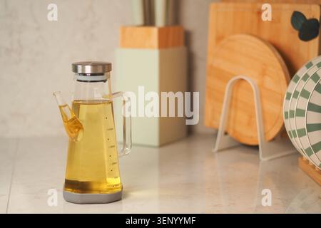 Oil dispenser sits on a kitchen counter with various items Stock Photo