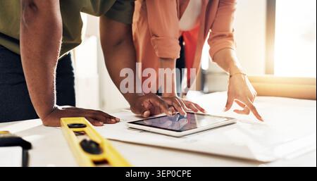Tablet, floor plan and hands of people in new home with discussion for renovation, building or repairs. Technology, blueprint and construction worker Stock Photo
