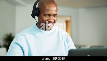 Laptop, headphones and black man in home for call center, crm or customer service with remote work. Mic, computer and African technical support agent Stock Photo