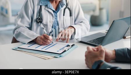 Clipboard, writing and hands of doctor with man in hospital for discussion on medical diagnosis. Documents, consultation and healthcare worker with Stock Photo