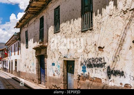 Cusco, Peru - March 23, 2025: A two story colonial building with heavily weathered and peeling plaster walls in the center of Cusco Stock Photo