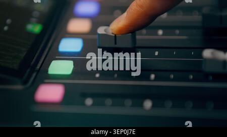 Audio Mixer Fader Potentiometer Sound Console Volume Control Slider CloseUp. High angle macro shot of a black fader knob with decibel scale markings o Stock Photo