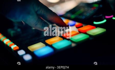 Music Producer Hand Adjusting Fader Digital Audio Workstation Studio Console Controller. A close-up shot captures a sound engineer's fingers precision Stock Photo