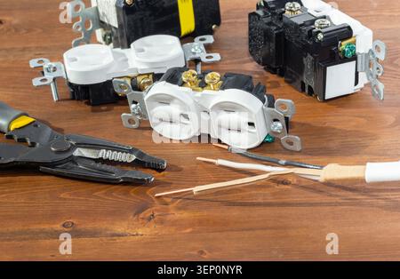 Electrical outlet, screwdriver and wire stripper tools on white background Stock Photo