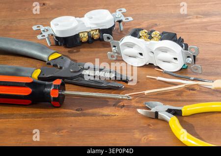 Electrical outlet, screwdriver and wire stripper tools on white background Stock Photo
