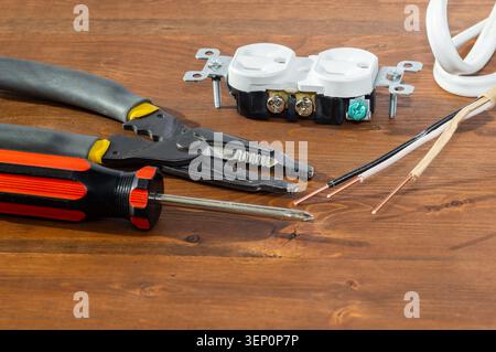 Electrical outlet, screwdriver and wire stripper tools on white background Stock Photo