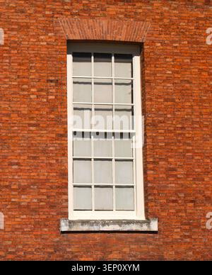 Single wooden multi framed window in a red brick wall Stock Photo