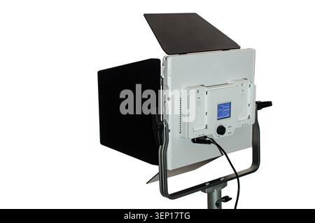 A rear view of a professional white LED panel light mounted on a stand, featuring adjustable barn doors, a digital control screen, and power cable con Stock Photo