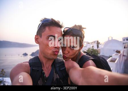 Couple taking selfie making funny faces in Santorini Stock Photo