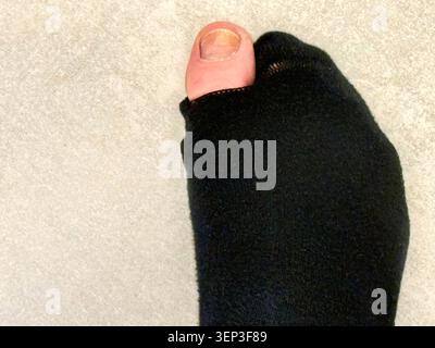 Hole in One Sock. Big Toe finding a hole in the sock. Stock Photo