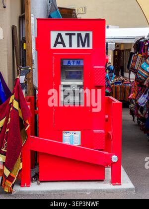 Santa Fe, NM - May 6 , 2026 - An ATM machine enclosed in a red cabinet serves those needing cash at a street mall in Santa Fe Stock Photo
