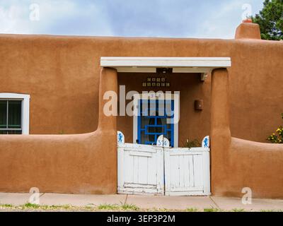 Santa Fe, NM - May 6 , 2026 - A small adobe house with a white gate at 314 Canyon Road Stock Photo