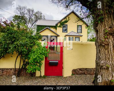 Santa Fe, NM - May 6 , 2026 - Yellow walls and a bright red gate make a colorful streetscene at 333 Canyon Road Stock Photo