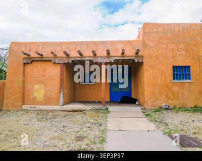 Santa Fe, NM - May 5, 2026 - A homeless person takes shelter under the roof of an abandoned adobe house Stock Photo