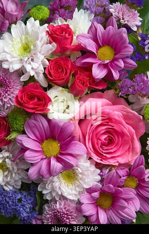 Close up view of a vibrant floral arrangement featuring pink roses, dahlias, chrysanthemums and white flowers. Stock Photo